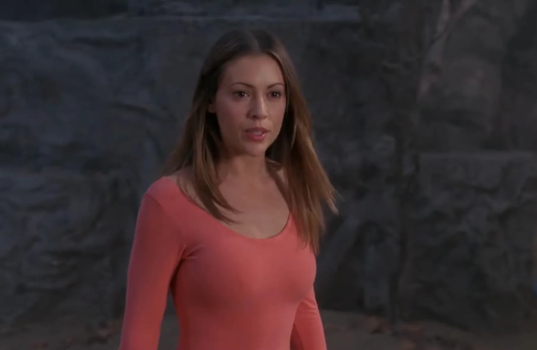 Halliwell sister from Charmed known for intelligence, caution, and strong sense of responsibility wearing a coral top outdoors.