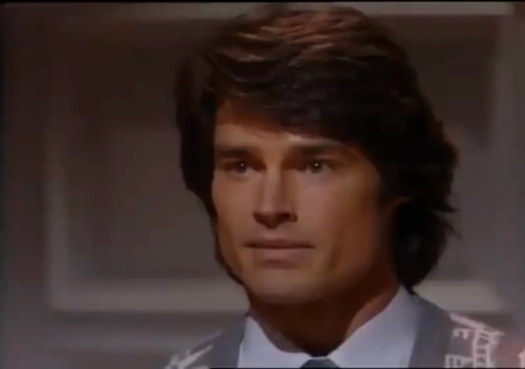 Ridge Forrester from The Bold and the Beautiful, wearing suit and tie, looking serious in an indoor setting.