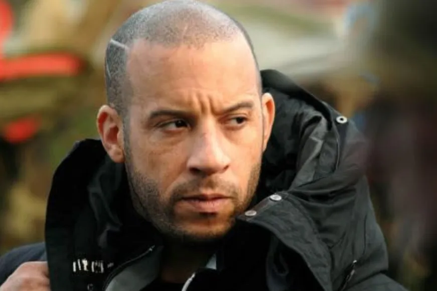 Vin Diesel in a black jacket looking thoughtfully to the side, representing Fast & Furious films star.