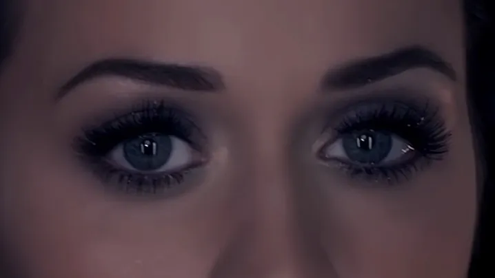 Close-up of celebrity eyes with long lashes and dark eye makeup, focusing on the mysterious gaze and facial features.