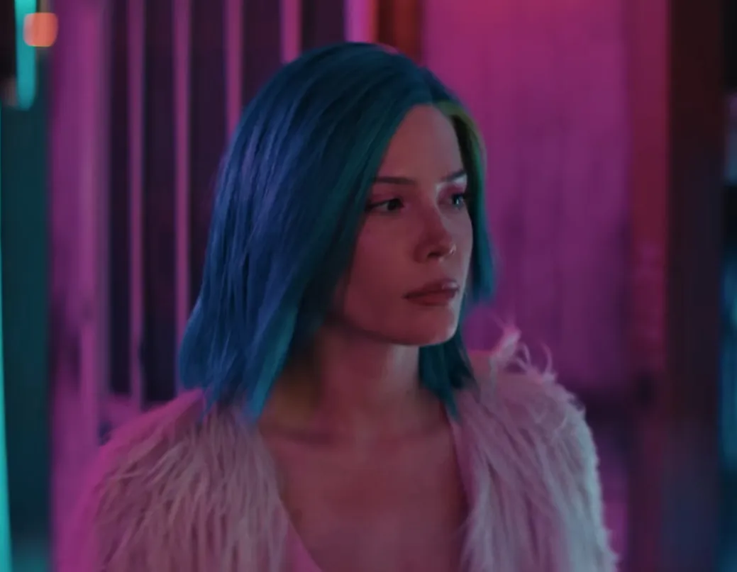 Young woman with blue hair and fur jacket looking away, highlighting celebrity eyes and Halsey features in colorful lighting.