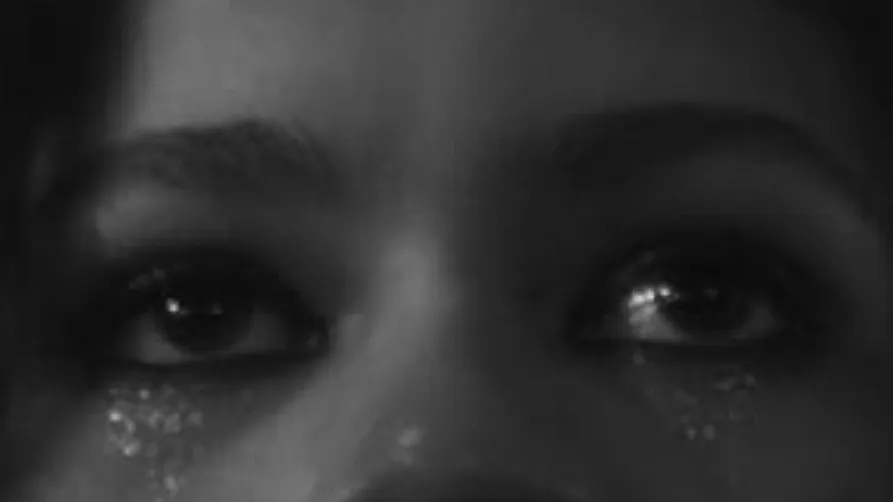 Close-up of celebrity eyes with shimmering makeup, capturing a mysterious and captivating stare.