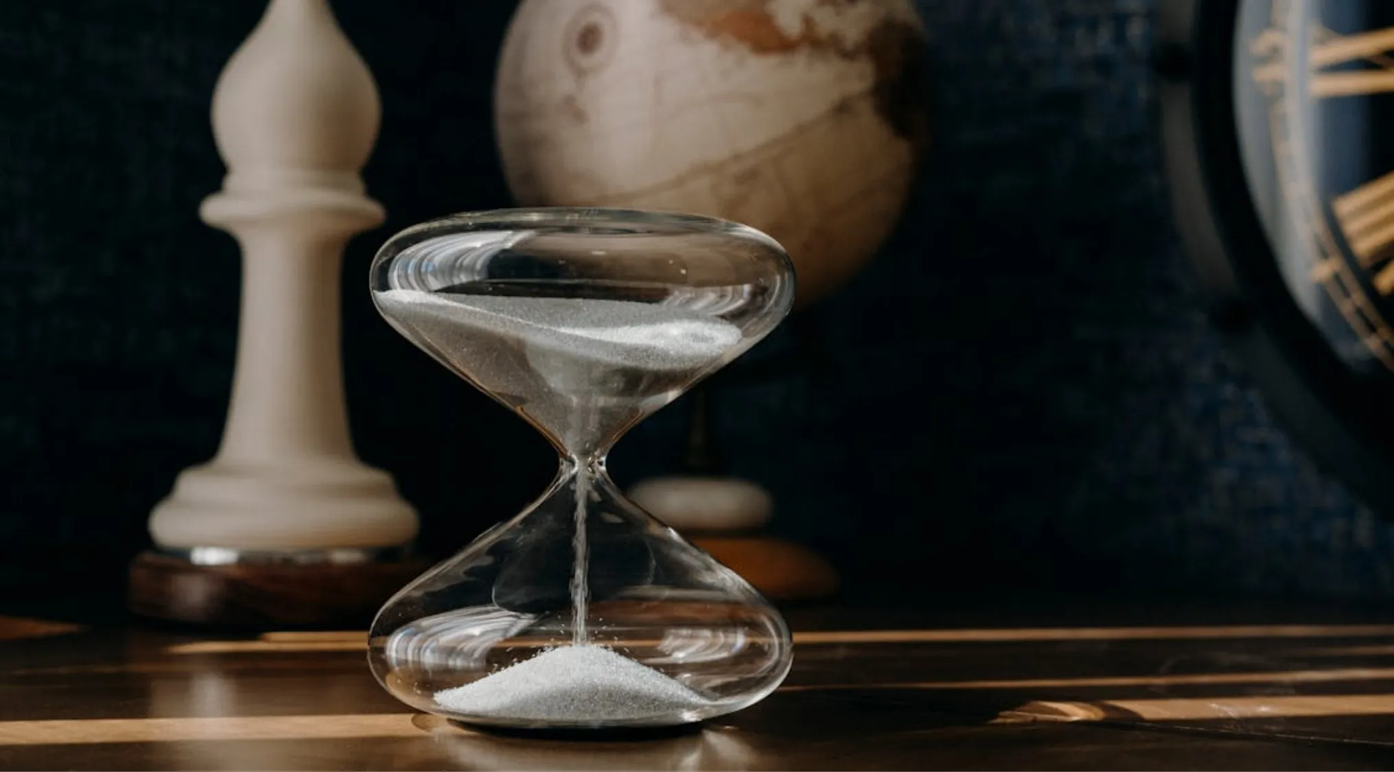 Hourglass on wooden table symbolizing delayed changes in Ireland and UK citizenship test question concept.
