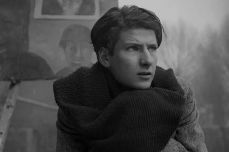 Young man wrapped in a thick scarf looking away thoughtfully, related to important contributor Pop Art movement.