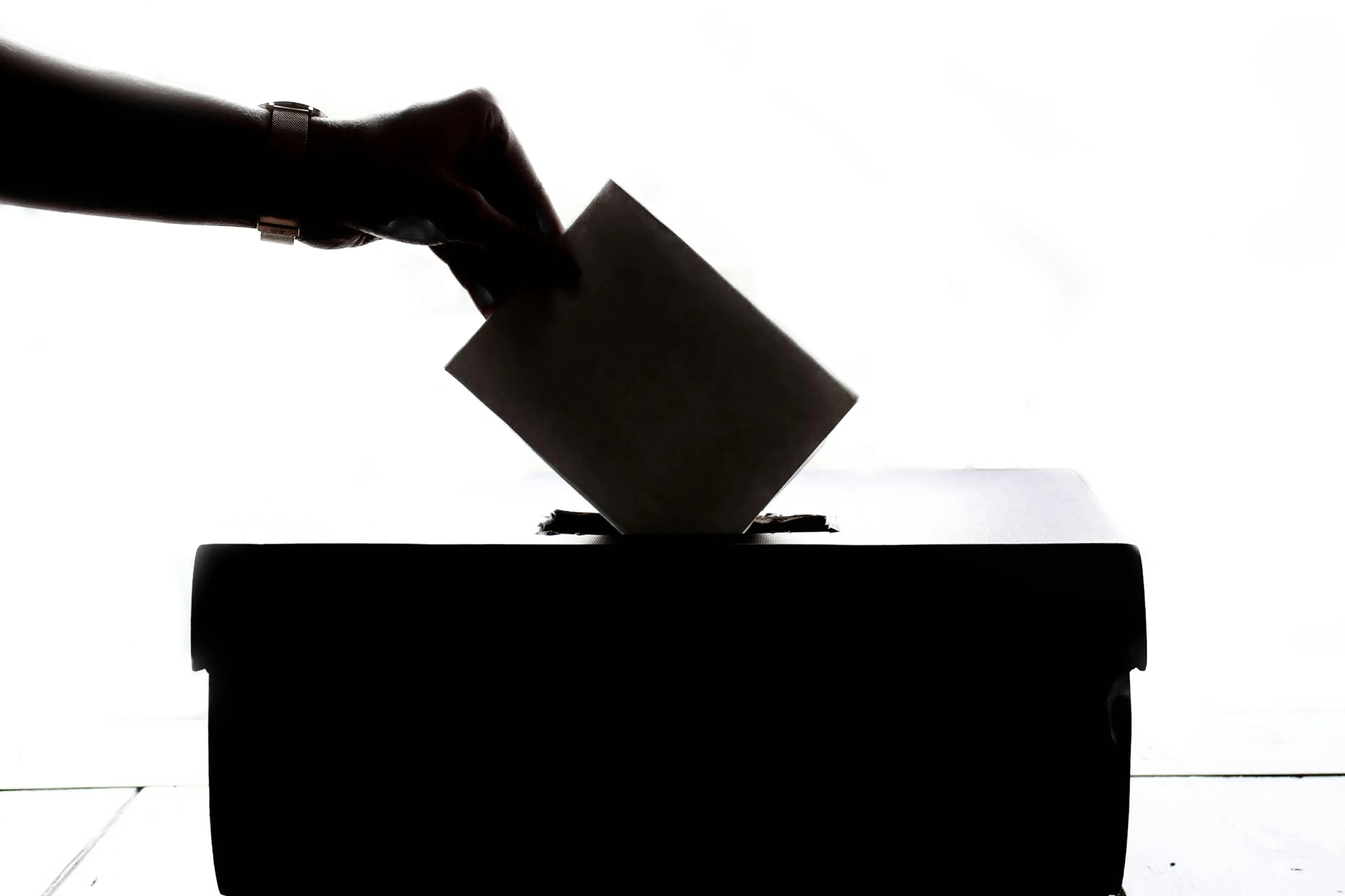 Hand placing ballot into box, symbolizing free and fair elections in a democracy for civic participation.