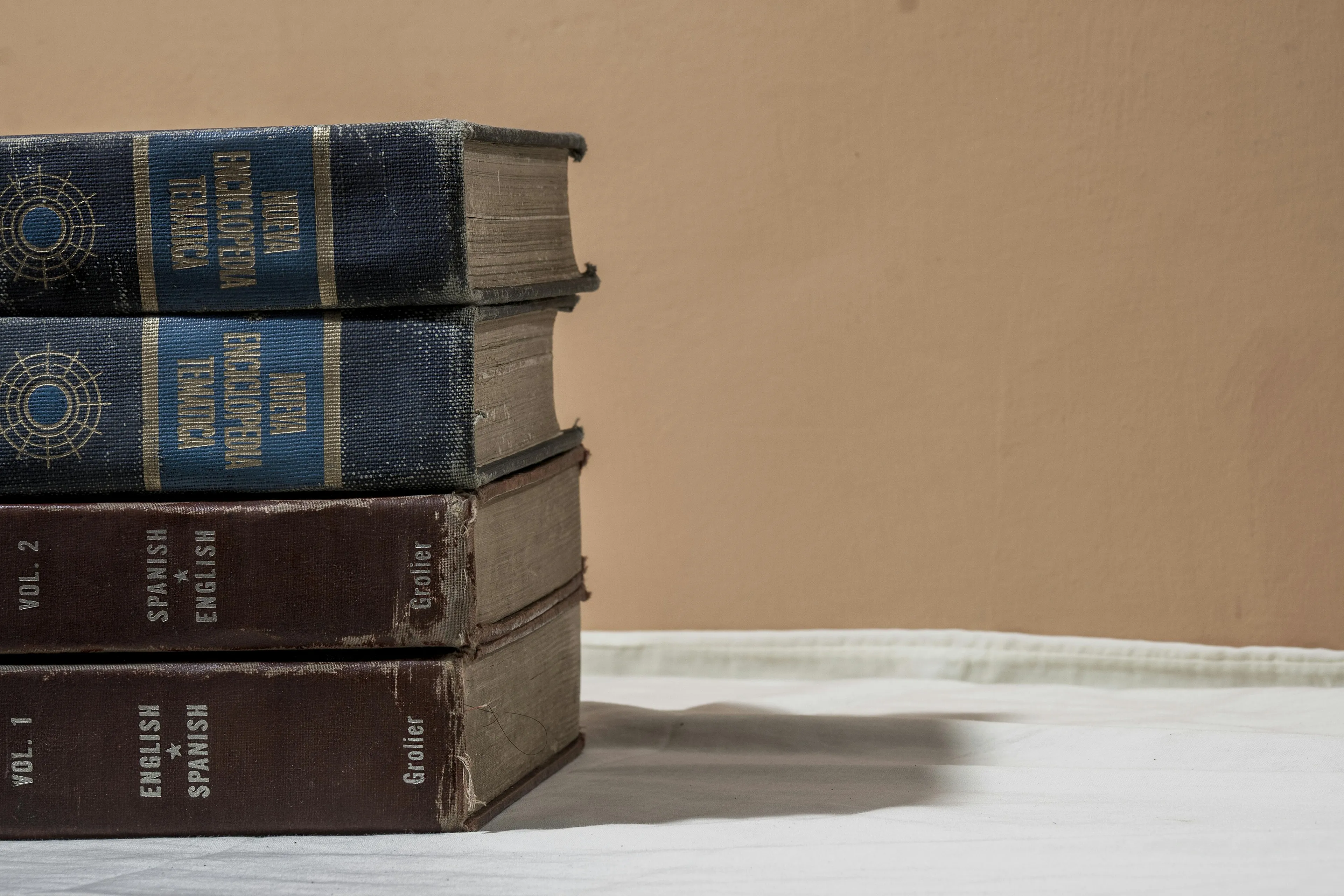 Stack of old thick books including English-Spanish dictionaries symbolizing civics and the constitution in a democratic country.