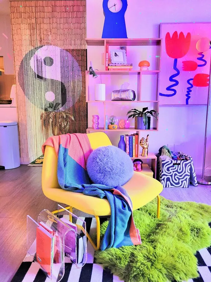 Colorful and eclectic living room decked out with bold decor, vibrant textiles, and unique art embracing more is more style.