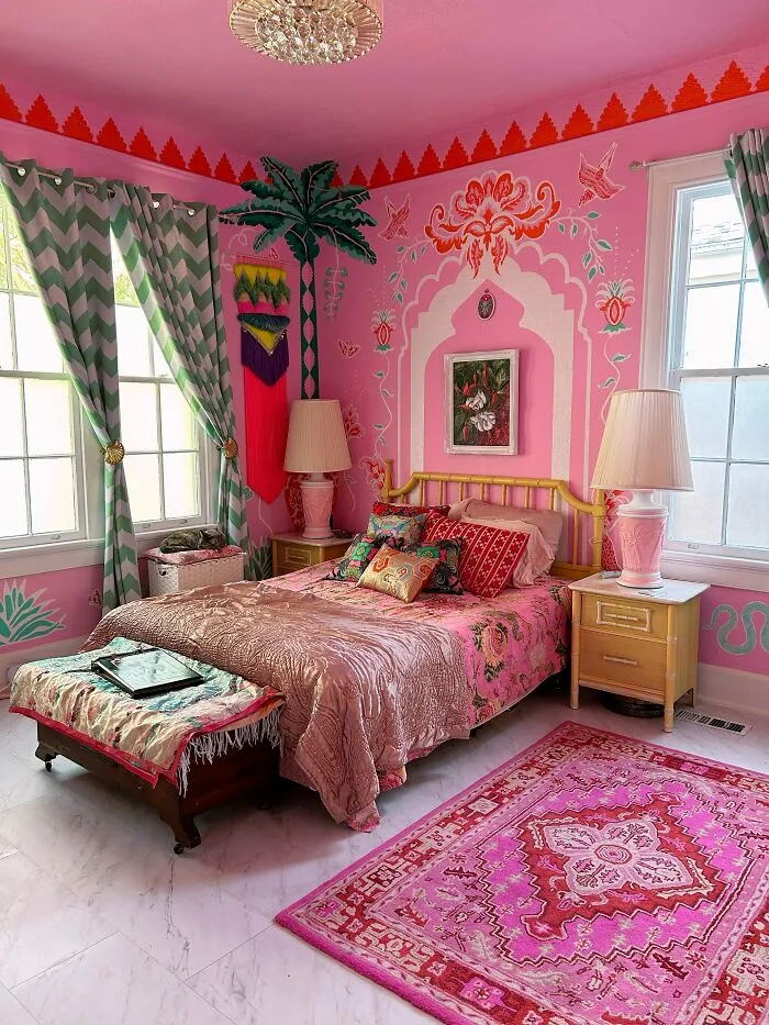 Vibrantly decorated bedroom showcasing a more is more style with bold patterns, bright pinks, and eclectic home decor elements.