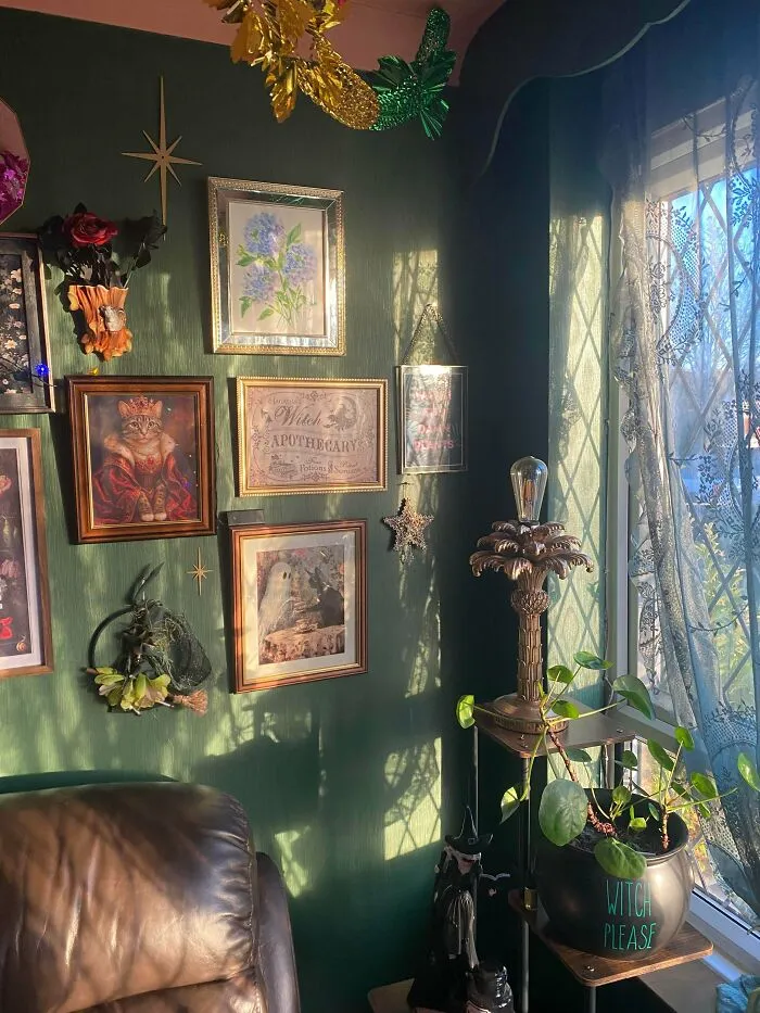 Cozy home corner decked out with eclectic wall art, plants, and vintage decor embracing more is more interior style.