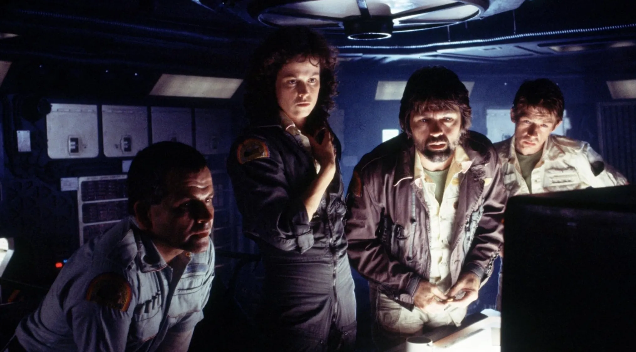 Crew members aboard a spaceship in a dark sci-fi setting from the movie Alien, highlighting the tagline quiz scene.