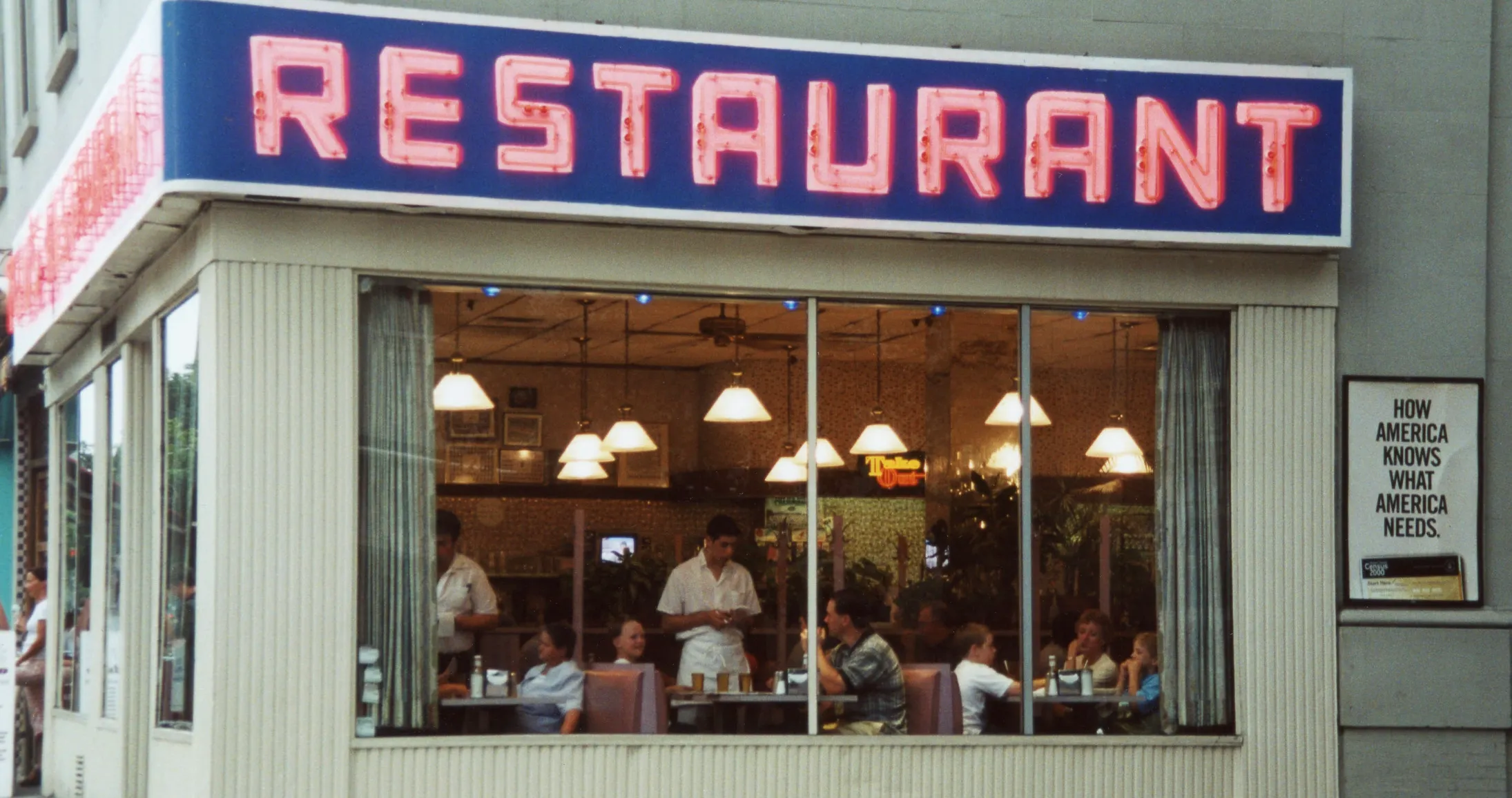 Exterior view of the fictional restaurant frequently featured in Friends, with diners visible through large windows.
