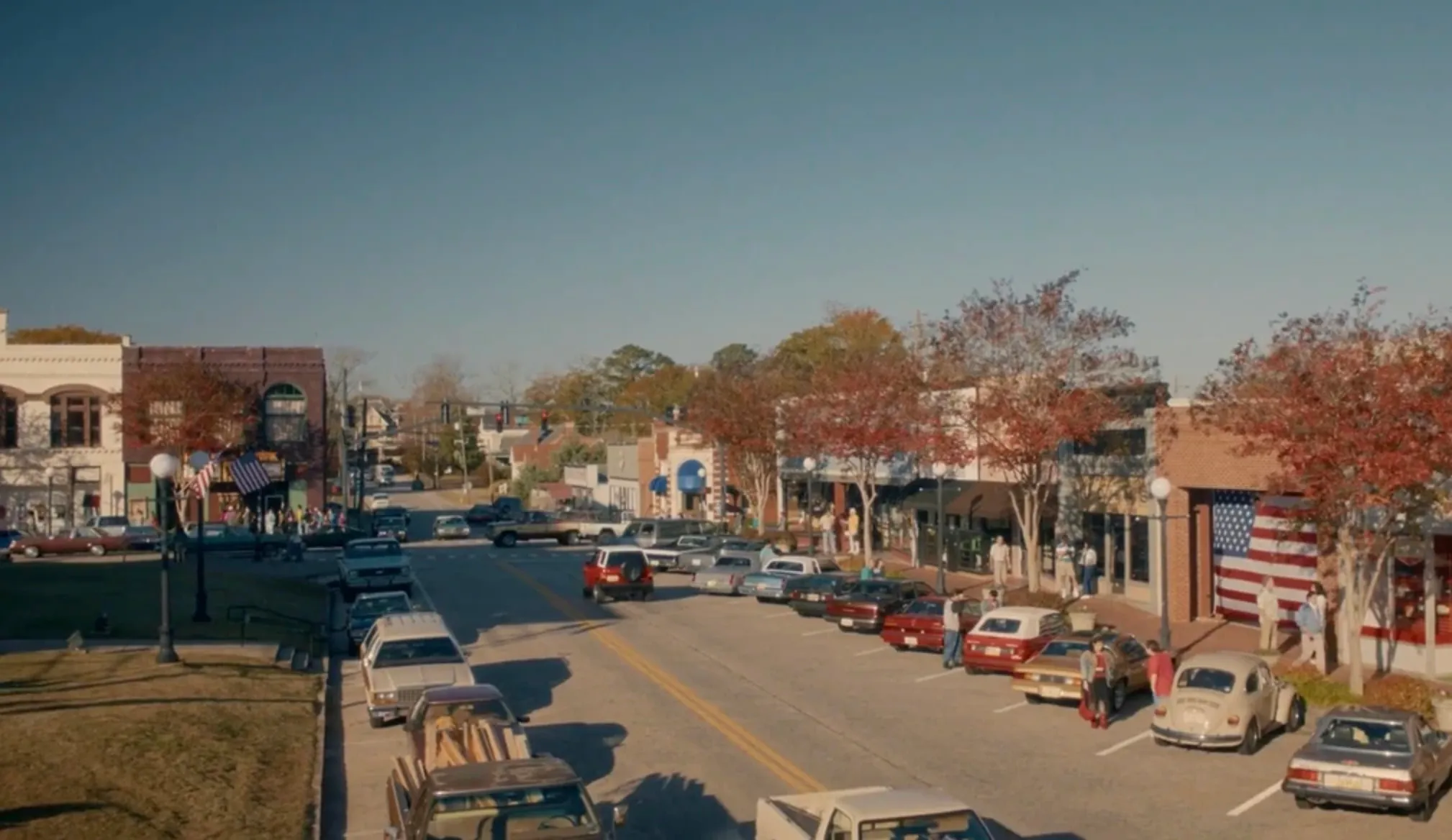 Main street scene of Hawkins, a fictional location featured in popular TV shows, with vintage cars and autumn trees.