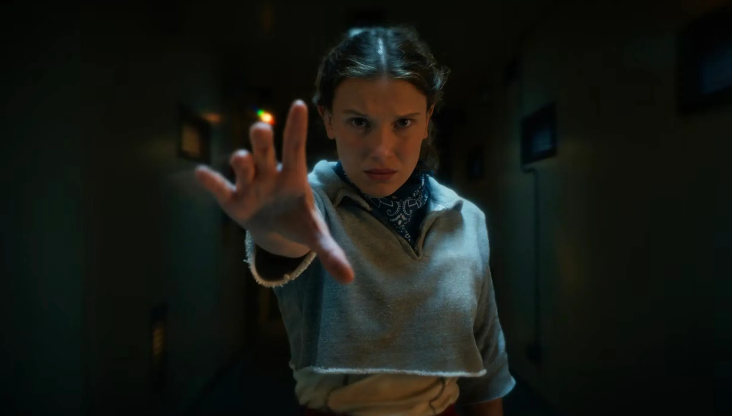 Eleven using her powers in a dimly lit corridor, relating to which characters study at Nevermore Academy.