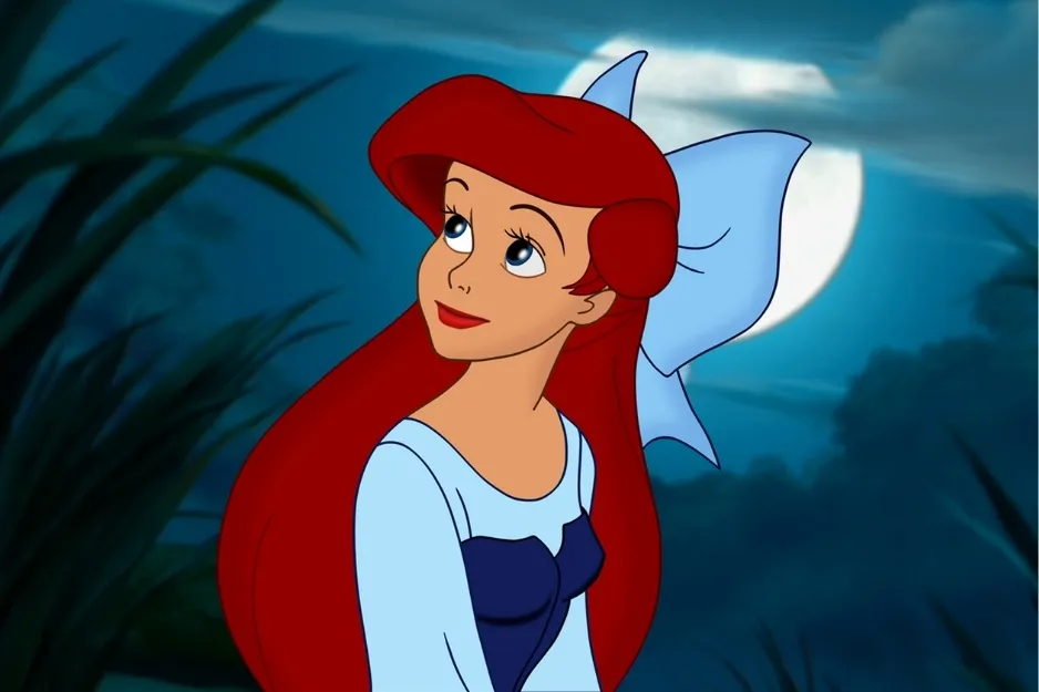 Disney princess known for her magical night at the ball wearing a blue dress with a large bow and red hair under the moonlight