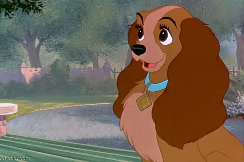 Animated character Lady, a kind-hearted dog with big ears and a blue collar, sitting outdoors on a sunny day.