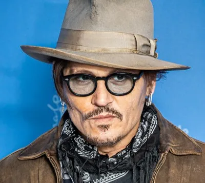 Johnny Depp wearing a hat, glasses, and a scarf.