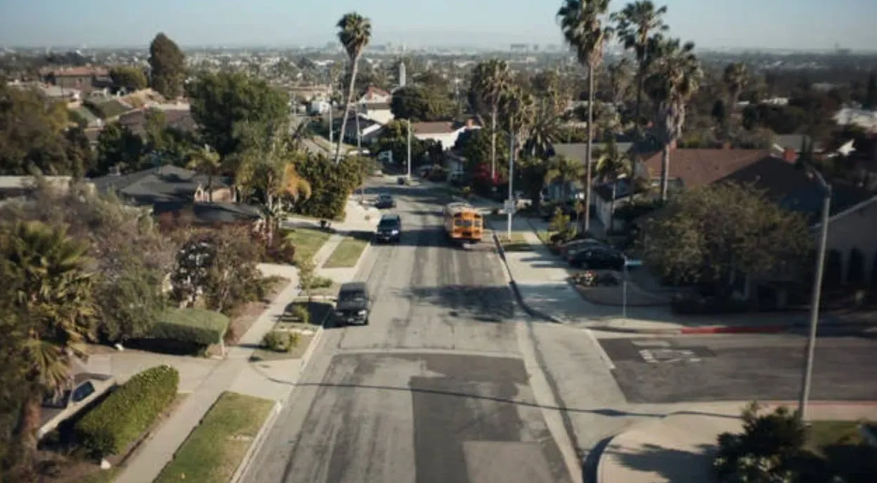 Aerial view of a suburban street with palm trees and a school bus in the fictional city of East Highland from a TV series.