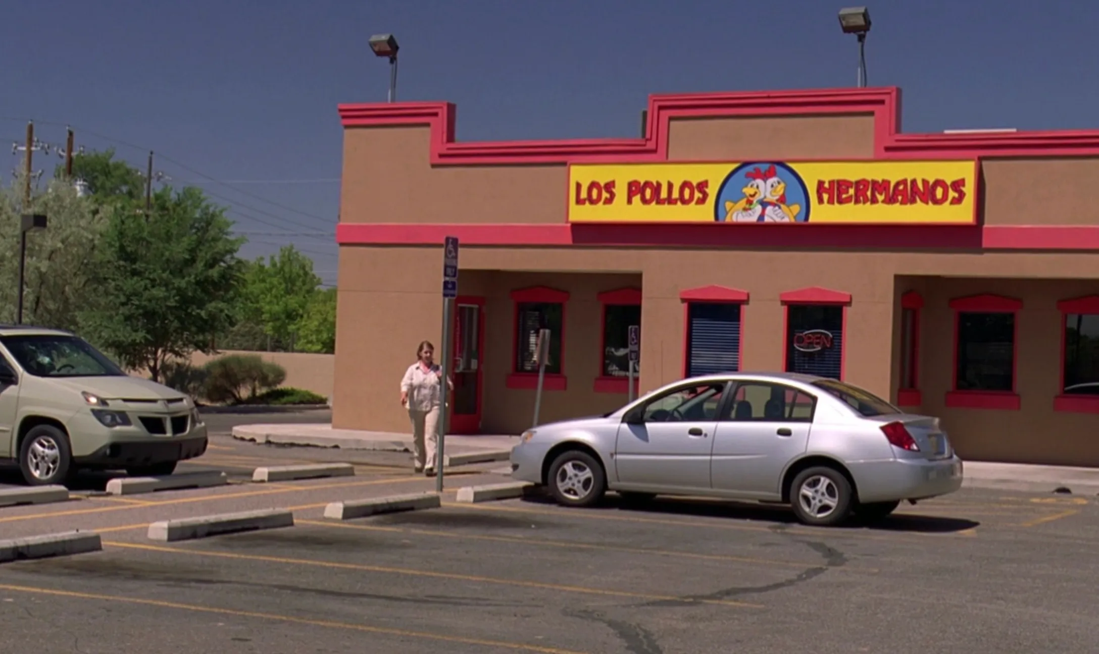 Fictional fast-food location Los Pollos Hermanos from a popular TV show, shown in a desert setting parking lot.