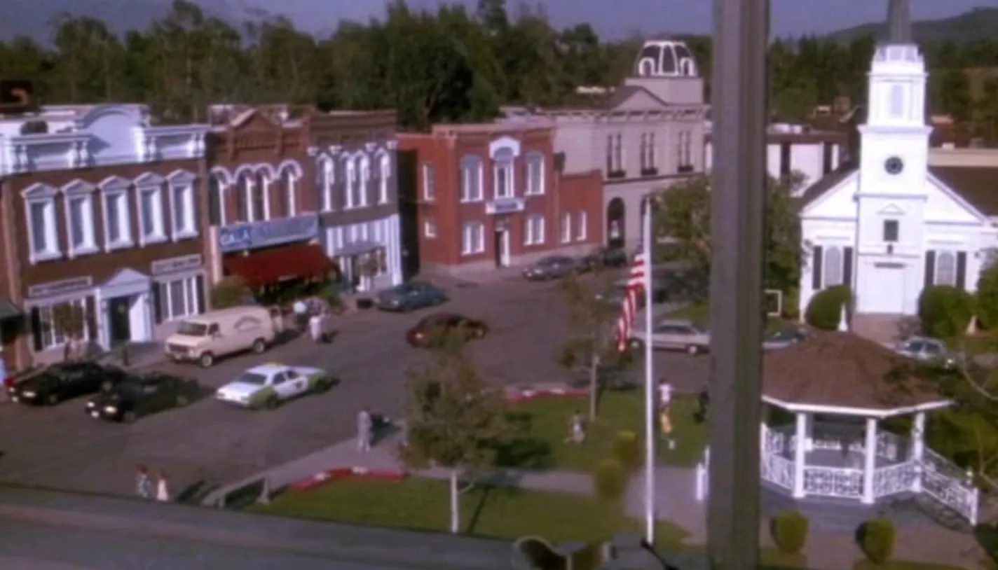 Downtown Rosewood, a fictional town in Pennsylvania, featuring shops, cars, and a white church in a TV show setting.