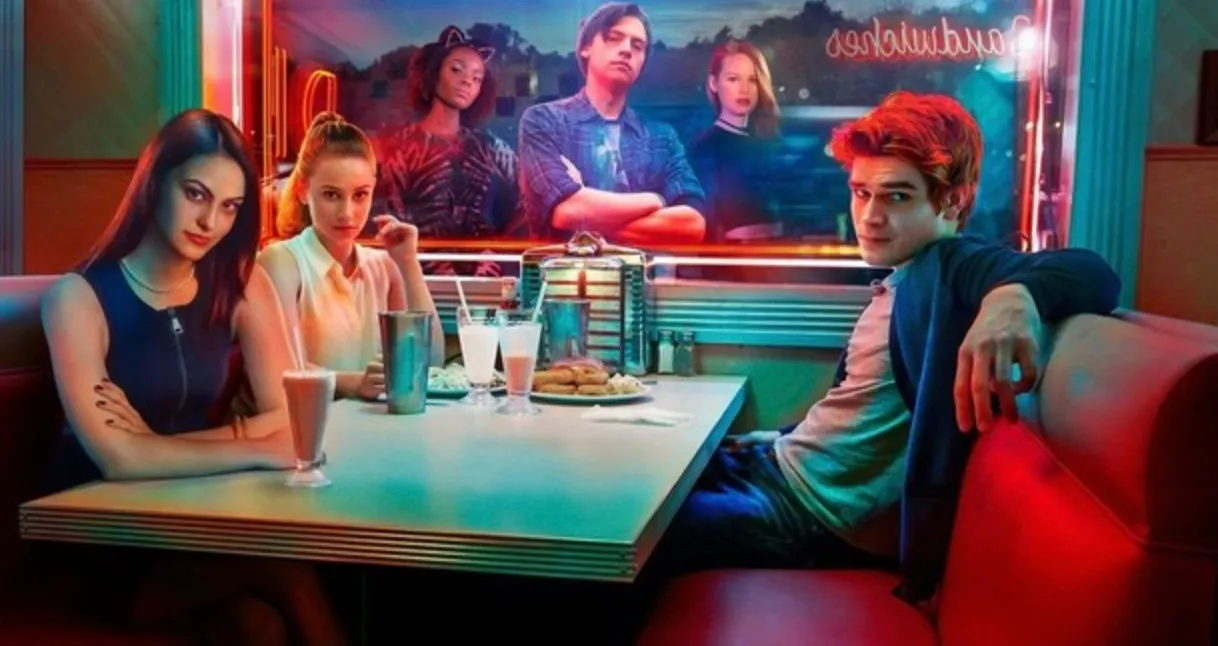 Main cast of a TV show sitting in a retro diner, representing fictional locations in TV shows and fictional towns.