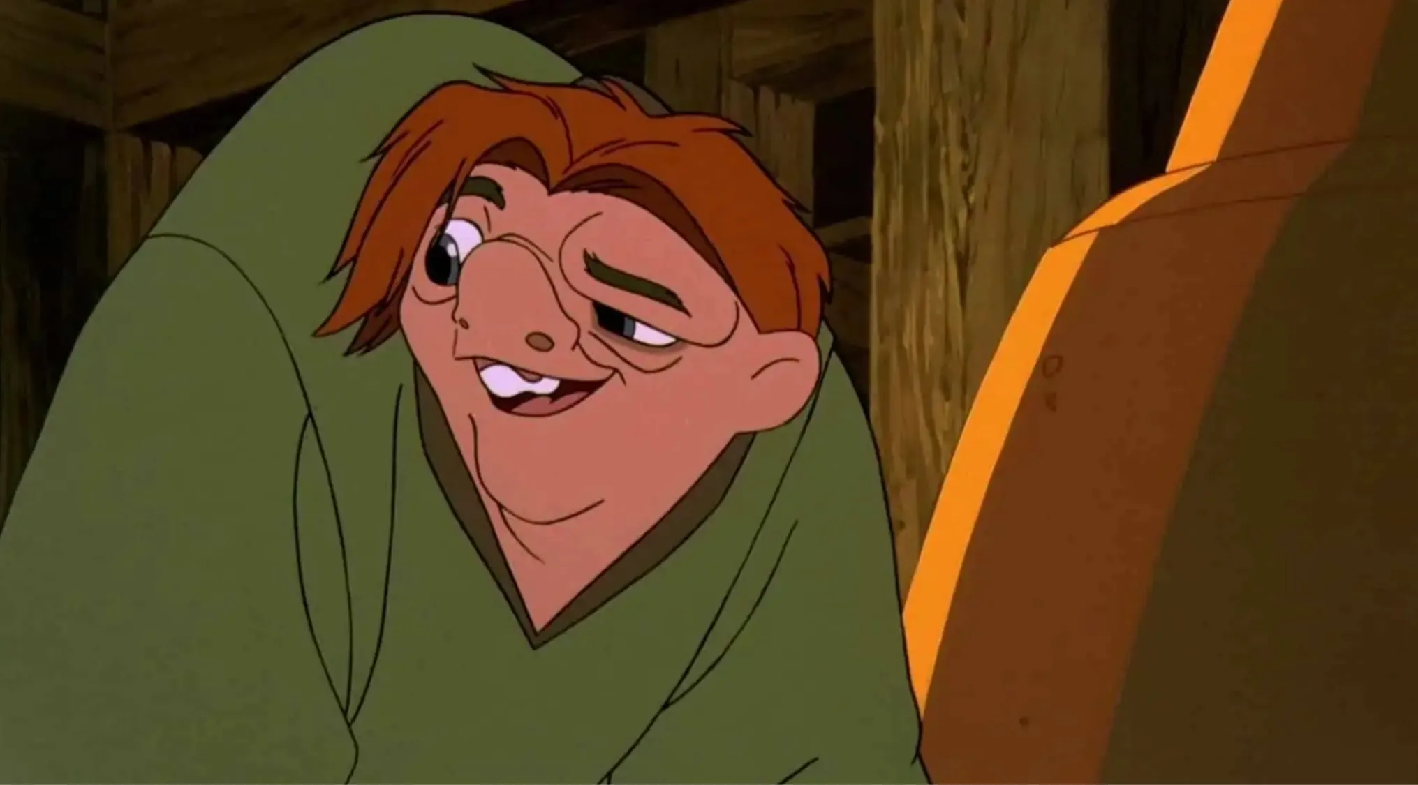 Disney character Quasimodo from The Hunchback of Notre Dame in a green outfit inside a wooden structure.