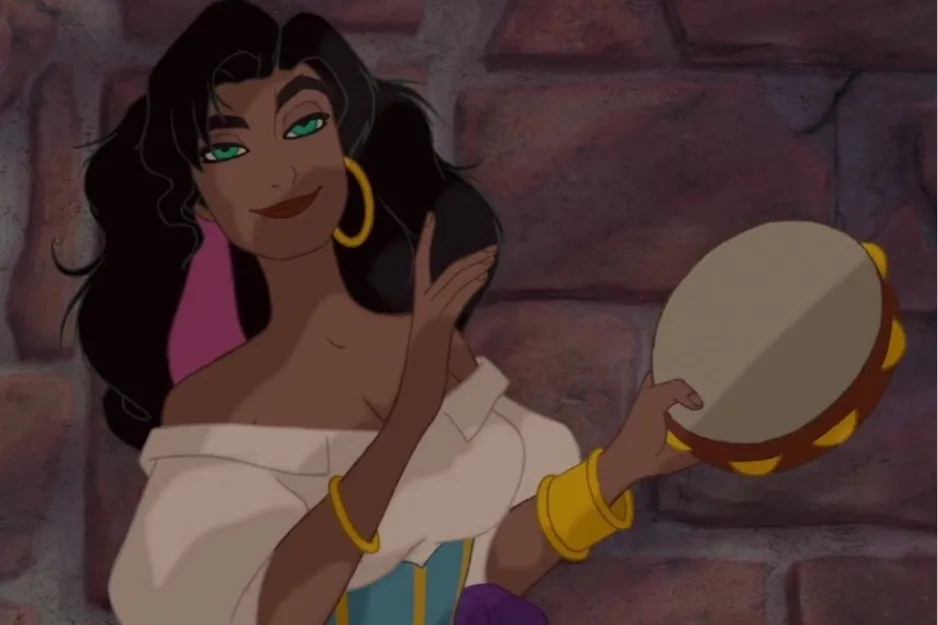 Esmeralda playing a tambourine, wearing gold jewelry and a white off-shoulder top with a colorful corset.
