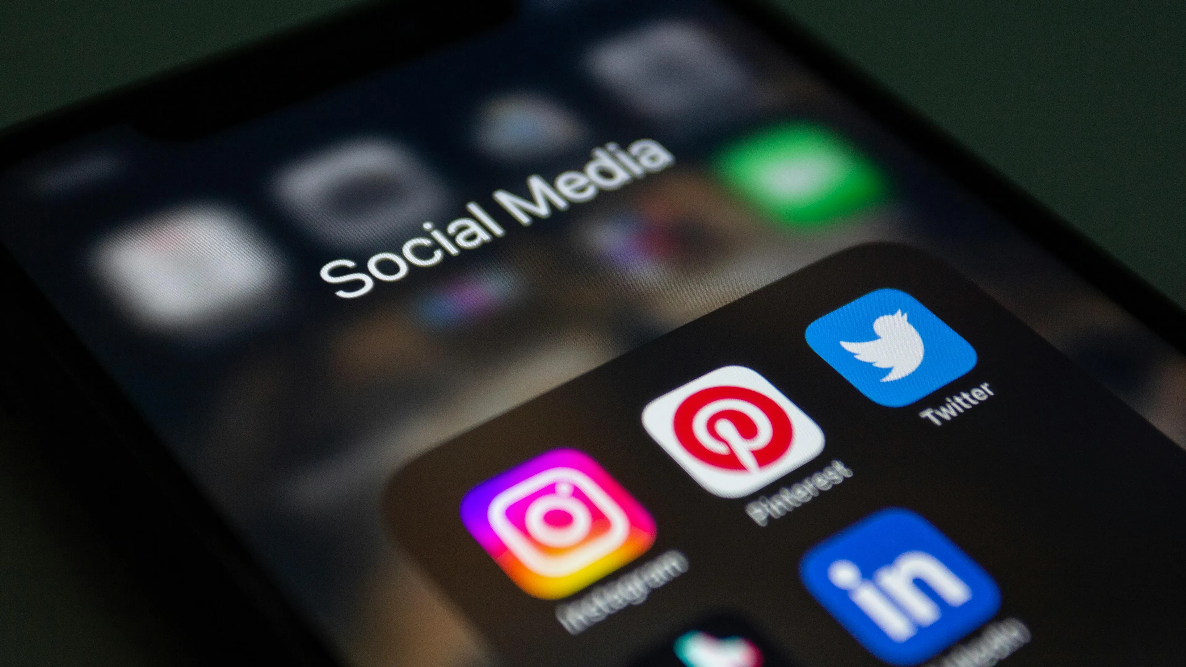 Smartphone screen displaying social media apps including Instagram, Pinterest, Twitter, and LinkedIn icons.