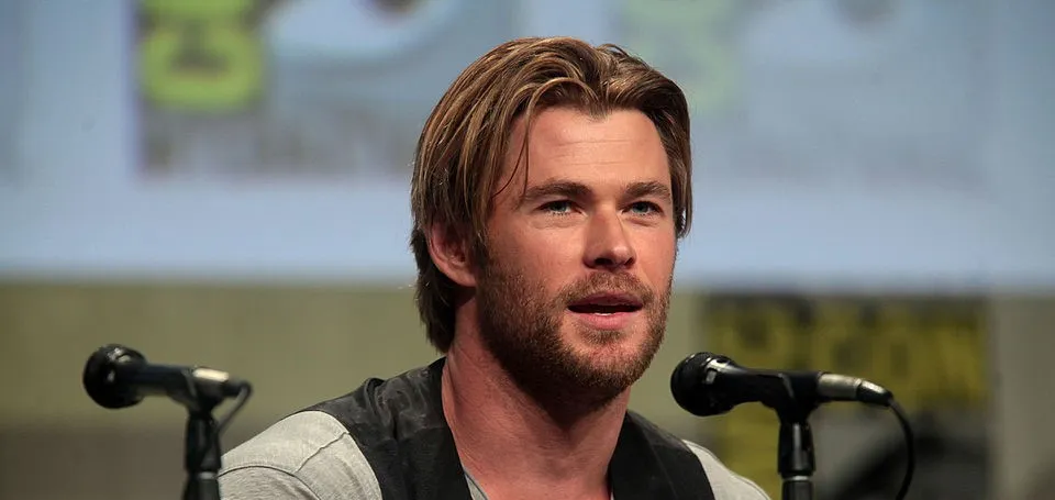 A man with light brown hair and beard speaking at a panel, not the actor who played Tony Stark Iron Man in Marvel Cinematic Universe.