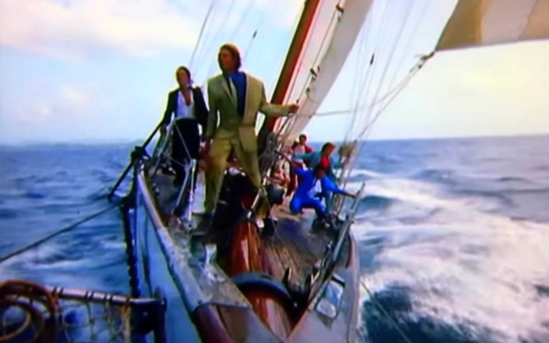 Duran Duran band members sailing on a yacht in the 1980s music video Rio with ocean waves in the background