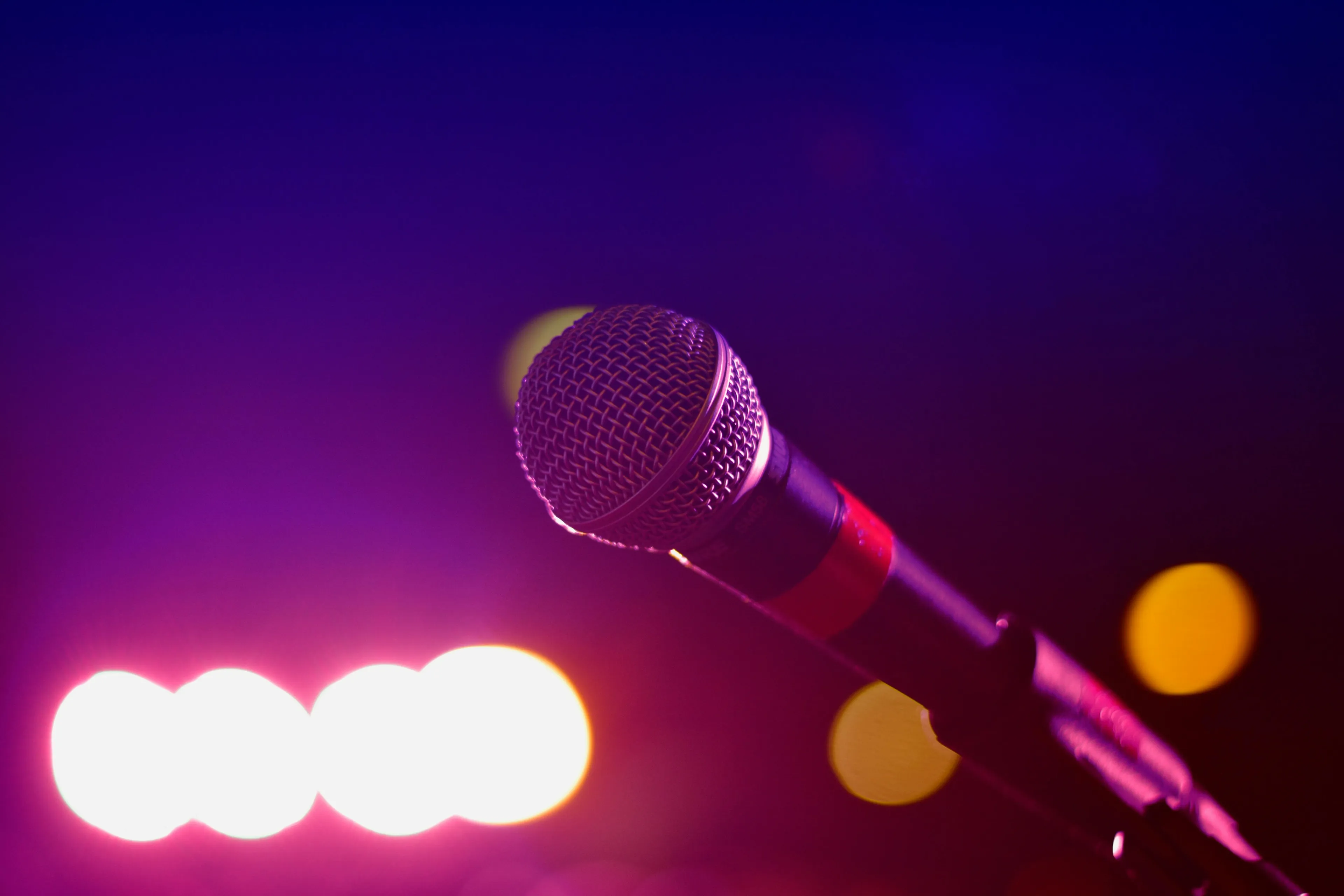 Close-up of a microphone on stage capturing the teen singing competition that inspired hit songs and fashion trends.