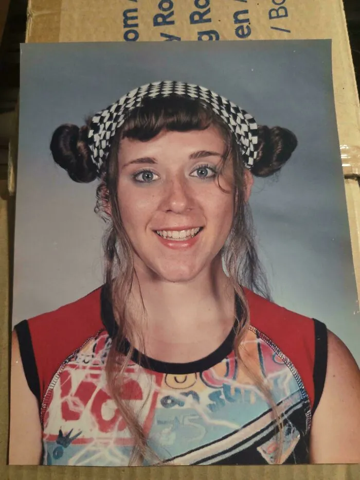 Young woman with uneven, tragic hair accident styled with pigtails and a checkered headband, showing hairstylist fail.