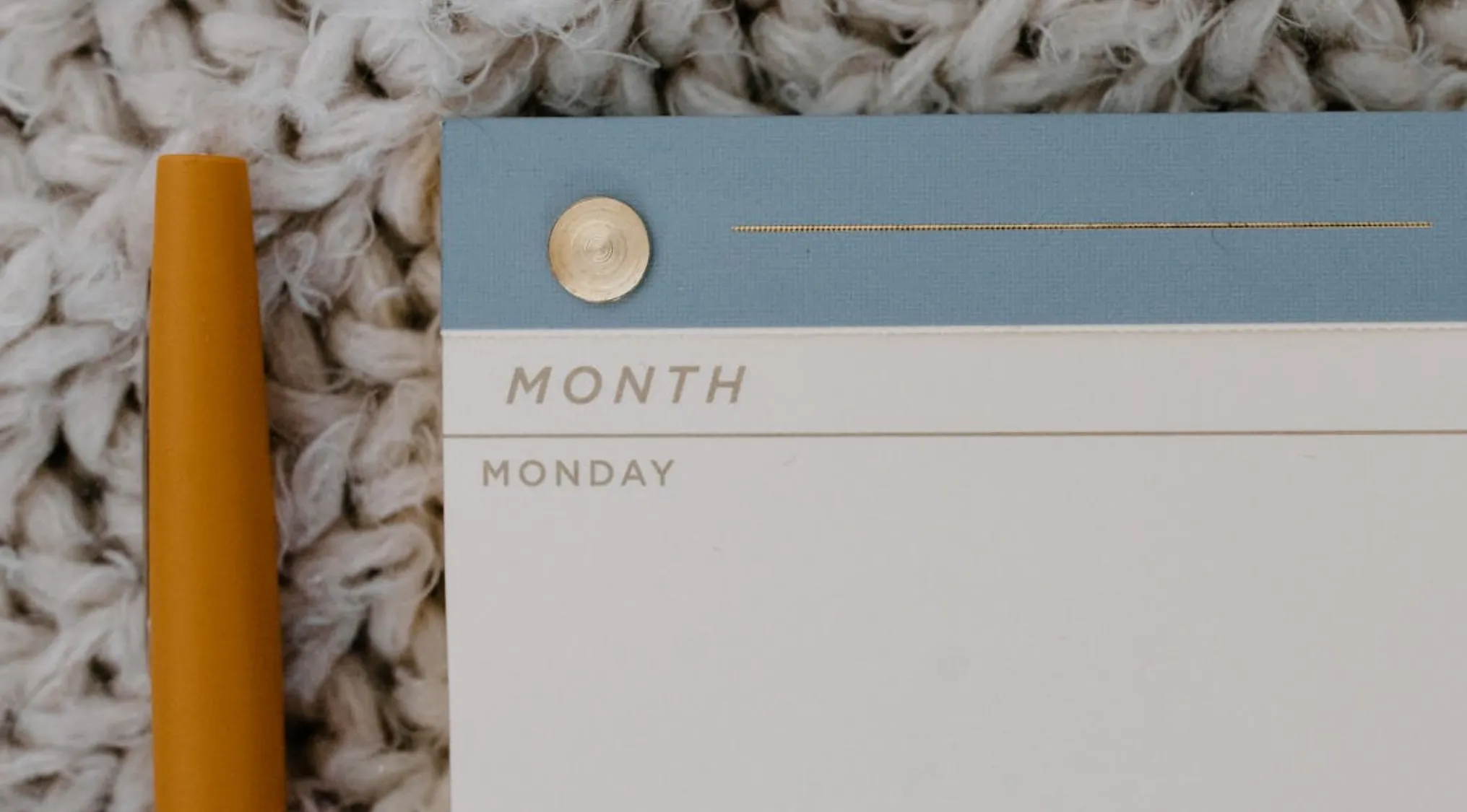 Close-up of a notepad displaying Monday with a pen nearby, representing basic math skills and day calculation concept.