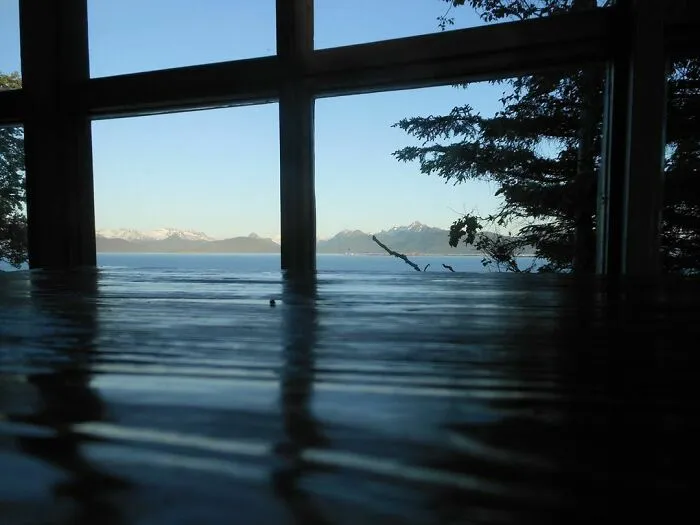Evening Light On A Wood Table Makes It Look Like Alaska's Kachemak Bay Is Pouring Into The Cabin