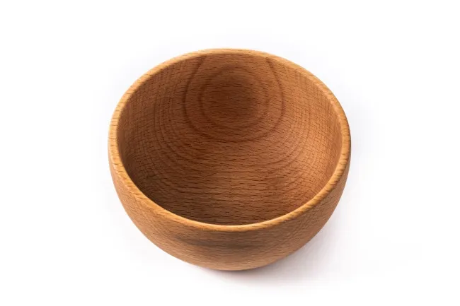 Empty wooden bowl on a white background symbolizing the concept of nothing or absence of a nostalgic snack.