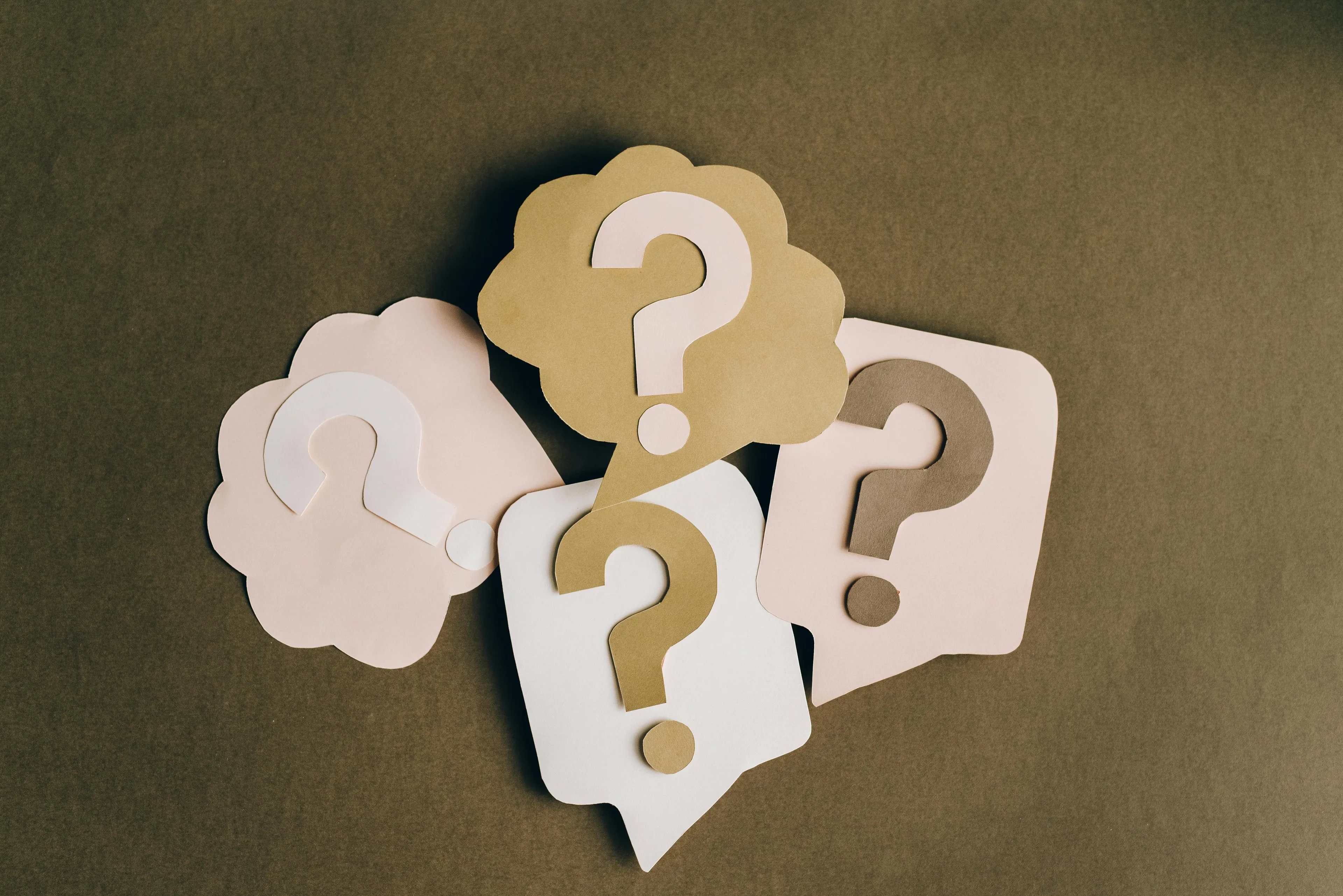 Paper cutouts of question marks in various shapes and colors representing an easy to maximum difficulty general knowledge quiz.