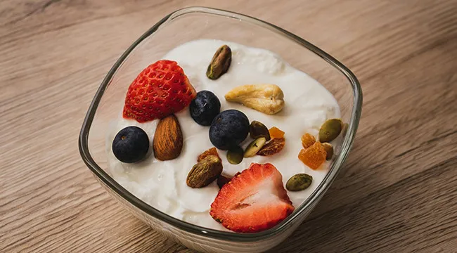 Bowl of yogurt with mixed berries and nuts illustrating psychological defense mechanism and gut reaction concept.