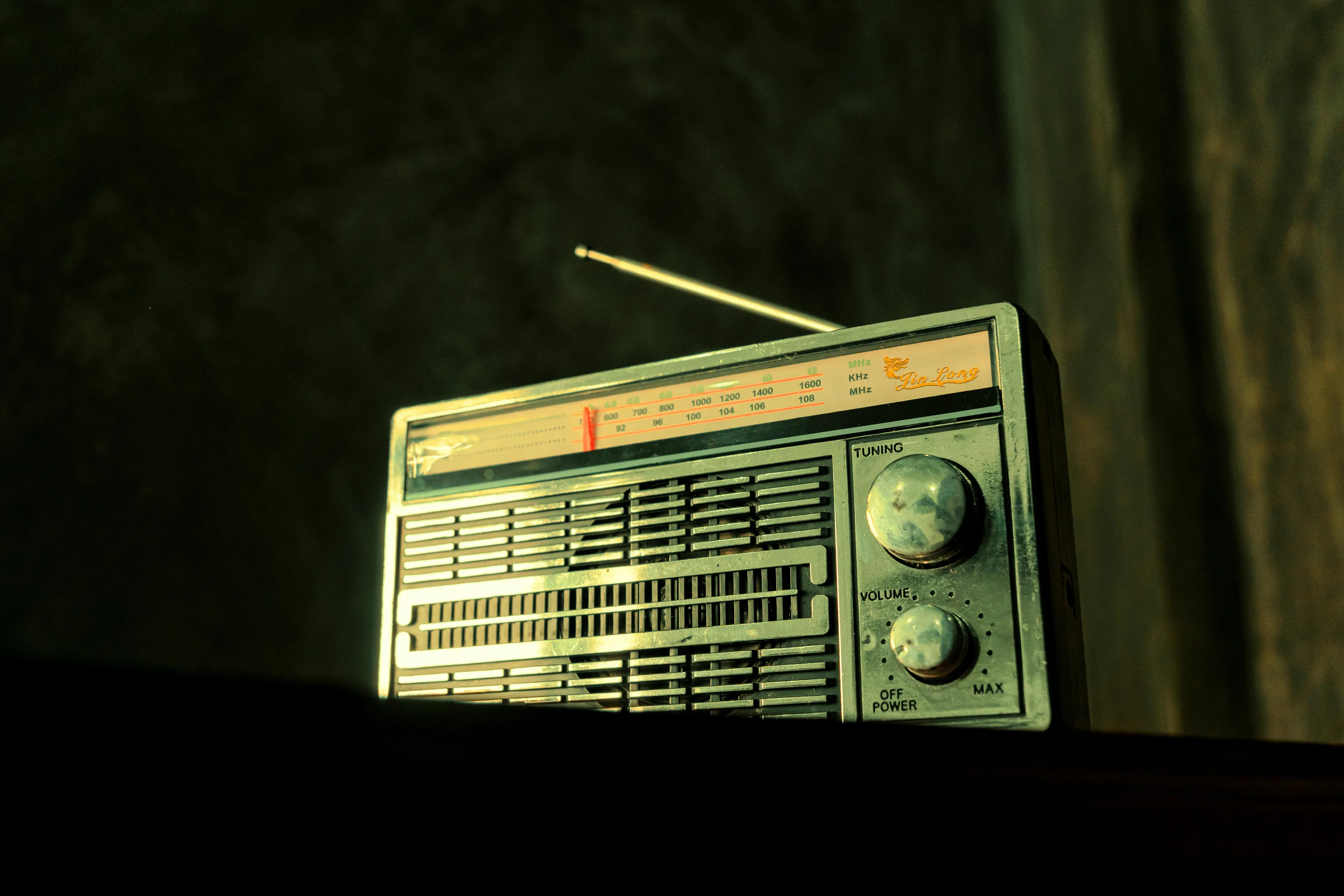Old vintage radio with antenna playing an unexpected high school song linked to psychological defense mechanism.