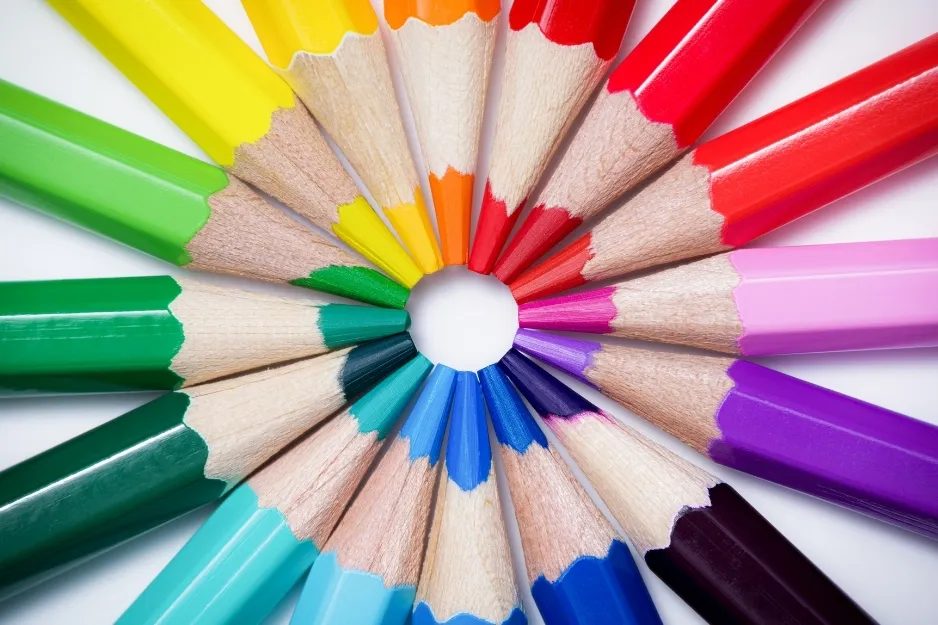 Colored pencils arranged in a circle showcasing a spectrum of colors representing the basics of color theory.