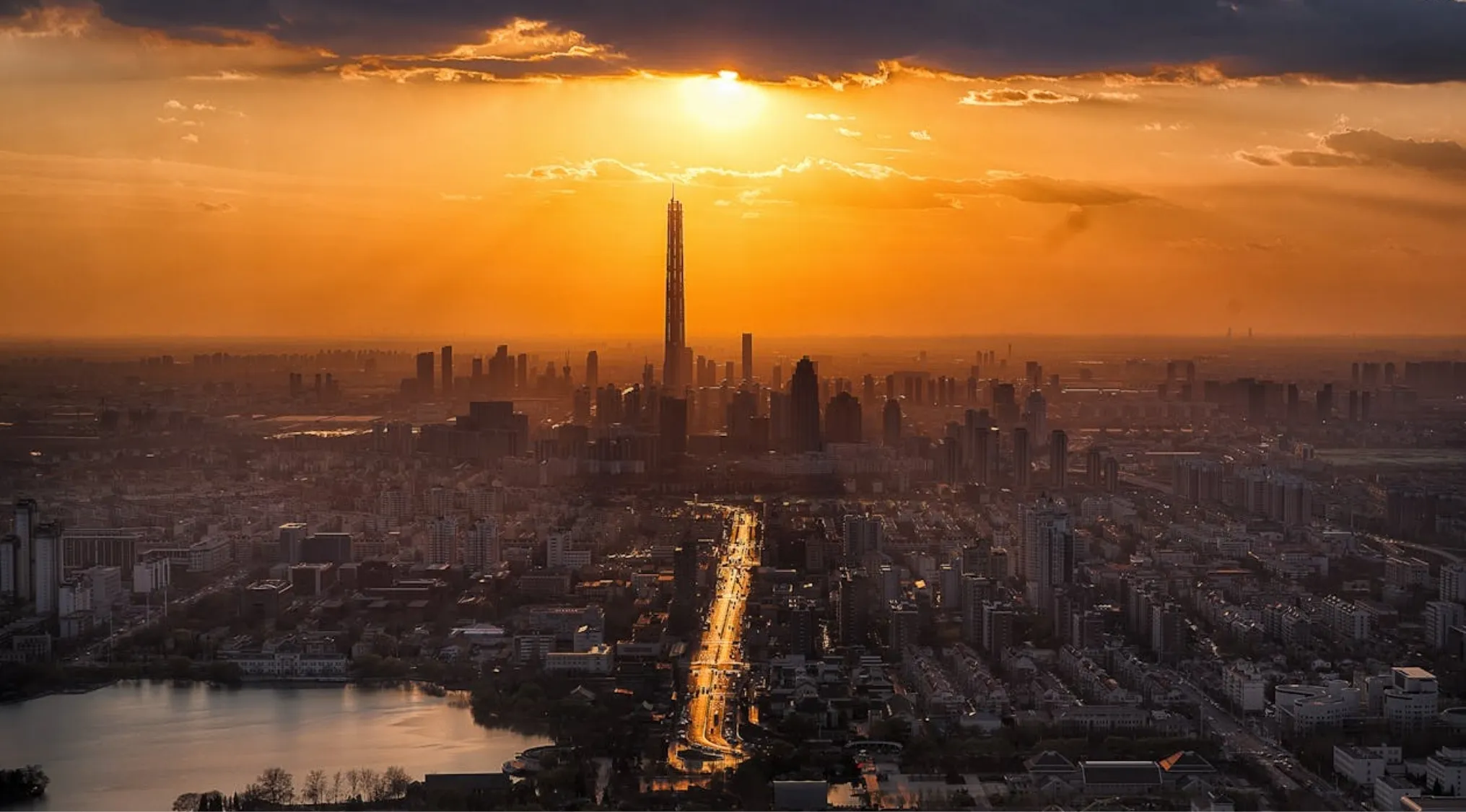Sunset cityscape with a prominent tallest building in the world towering over the urban skyline and streets below.