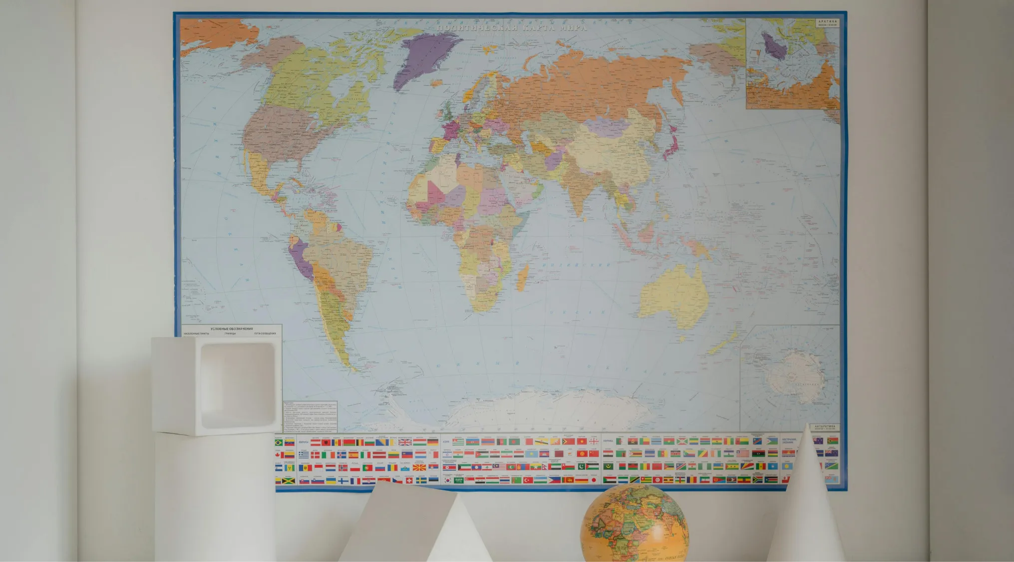 World map on wall with geometric shapes and globe, illustrating location differences between Tanzania and Tunisia.