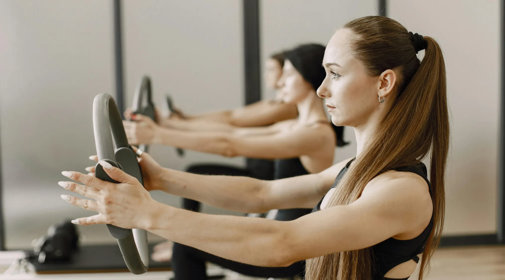 Women in a Pilates studio using equipment, focusing on workout and fitness in an Advanced Placement school quiz on statistics.