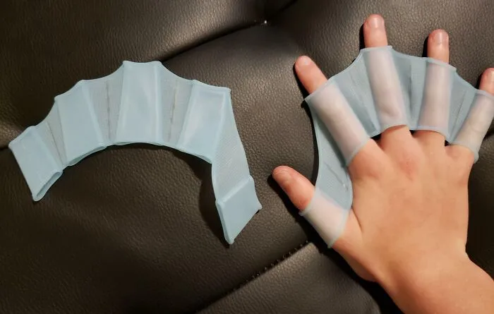Una mano con aletas de natación azules y una aleta suelta. Una de muchas herramientas que podrían simplificar tu vida.