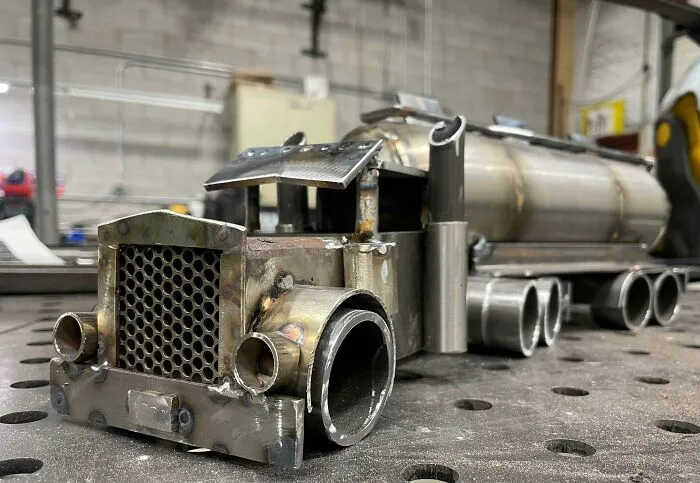 Metalworkers’ intricate metal truck model showcasing skill and creativity in defying physics and logic with remarkable craftsmanship.