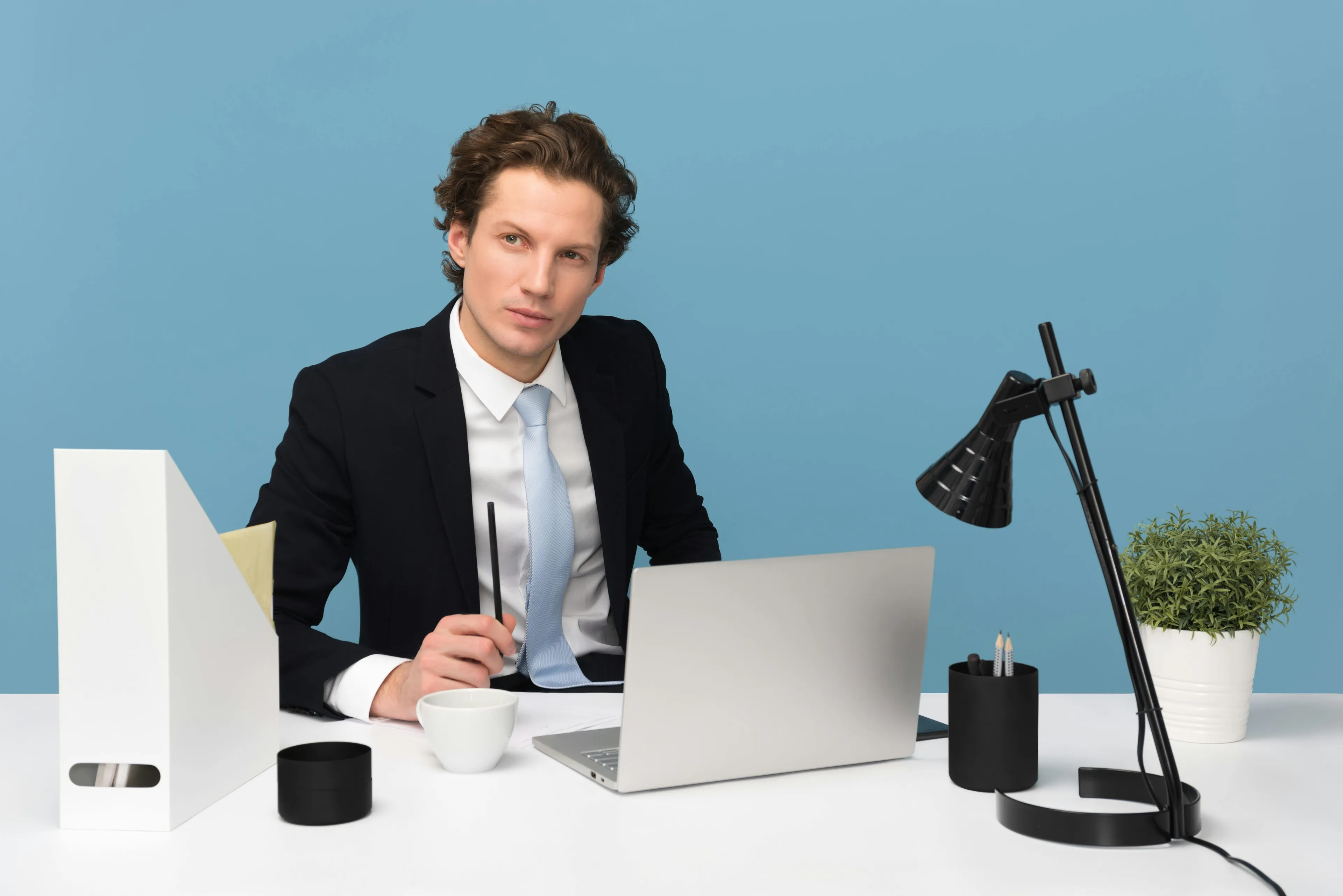 Young man in a suit working on a laptop, reflecting on countries that are often mixed up, including Great Britain and UK.