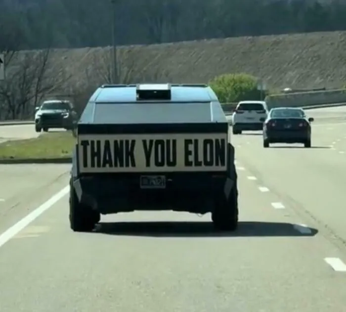 Cartel gigante de "Gracias Elon" detrás de un Cybertruck