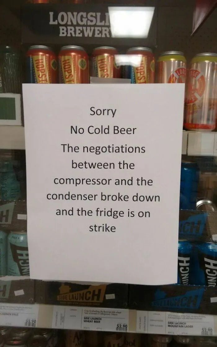A strange sign humorously explains no cold beer due to a fridge strike caused by compressor and condenser negotiations.