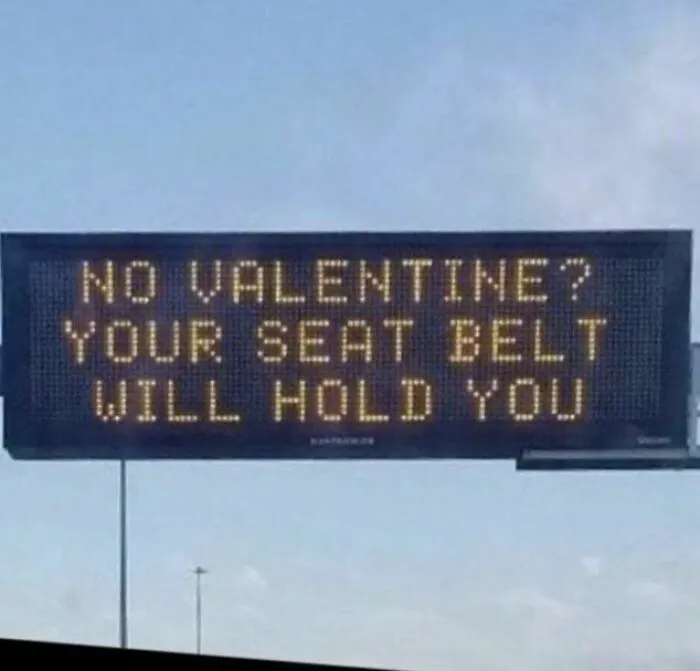 Funny strange road sign humorously reminding drivers to wear seat belts even without a valentine, part of strange signs collection.