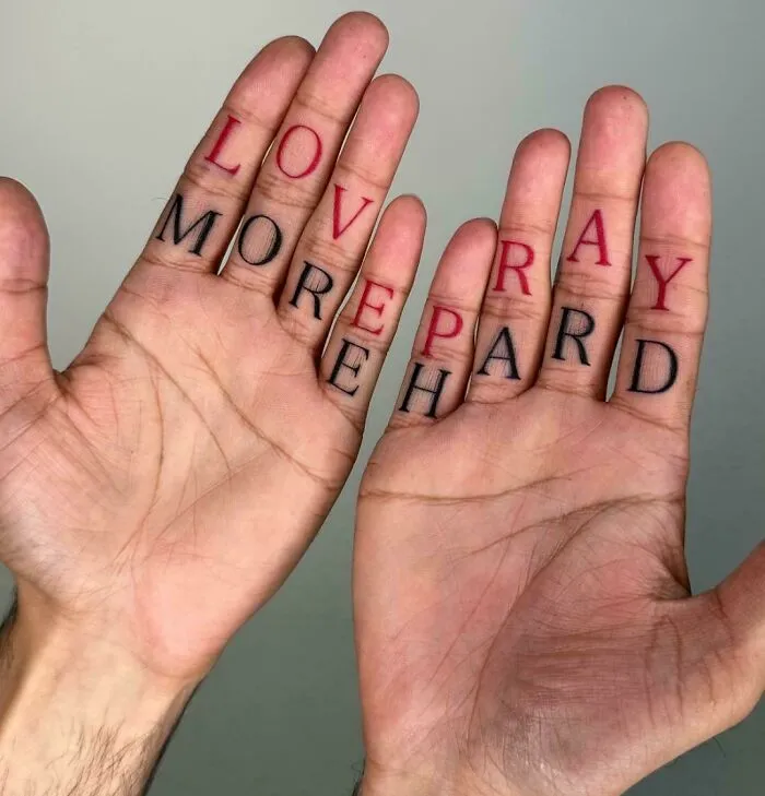 Hands with tattoos spelling love more pay hard, an example of signs that went so wrong they turned into comedic gold.