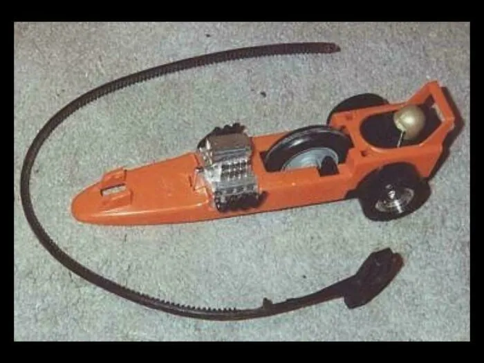 Orange toy race car with a long, flexible black track, evoking images that take you way back to childhood fun.