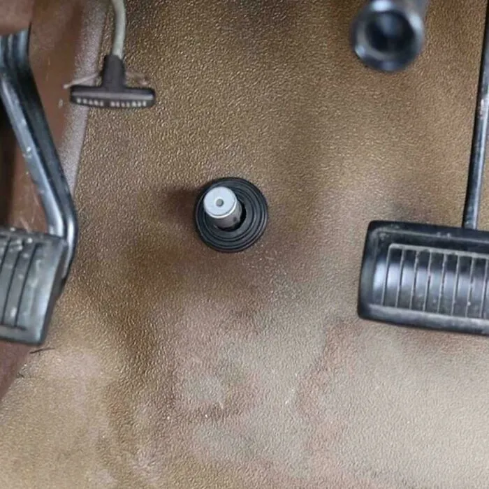 A close-up of a car floor with a high beam dimmer switch, a nostalgic image that might take you way back.
